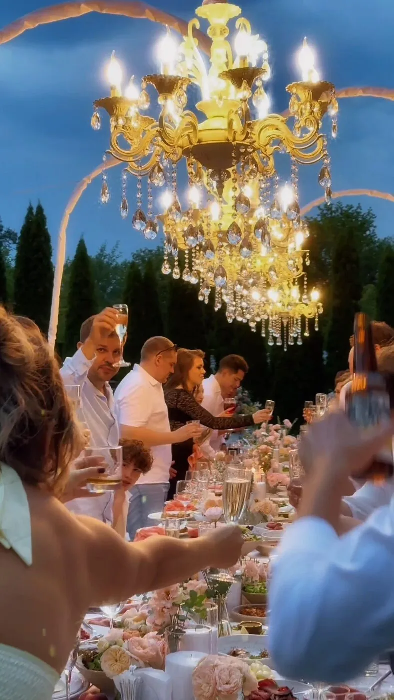 Recepție de nuntă cu candelabru, invitați ridicând paharul