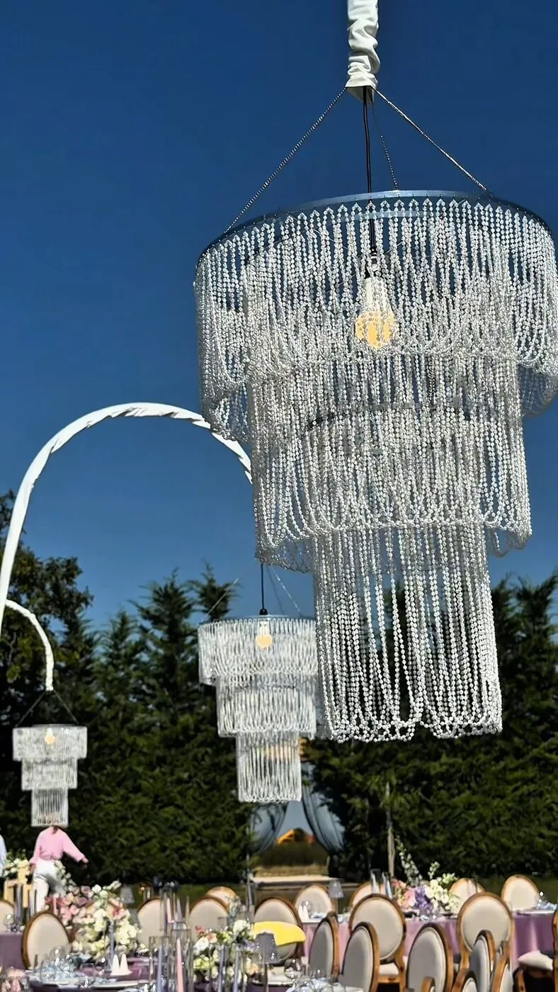 Candelabre suspendate deasupra meselor de nuntă, la apus