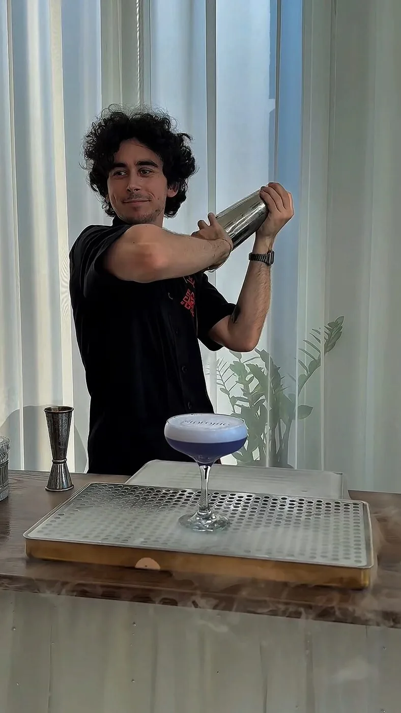 Barman preparând un cocktail la shaker