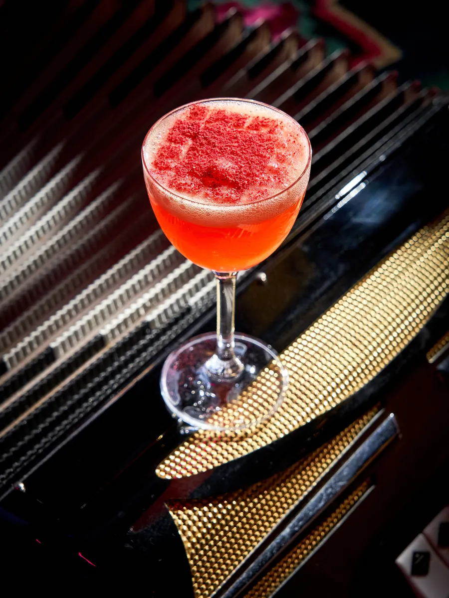 Cocktail Balada pentru Ea — vodcă de fructe roșii și Amaretto, în pahar coupe cu pudră de zmeură, COVOR BAR Chișinău